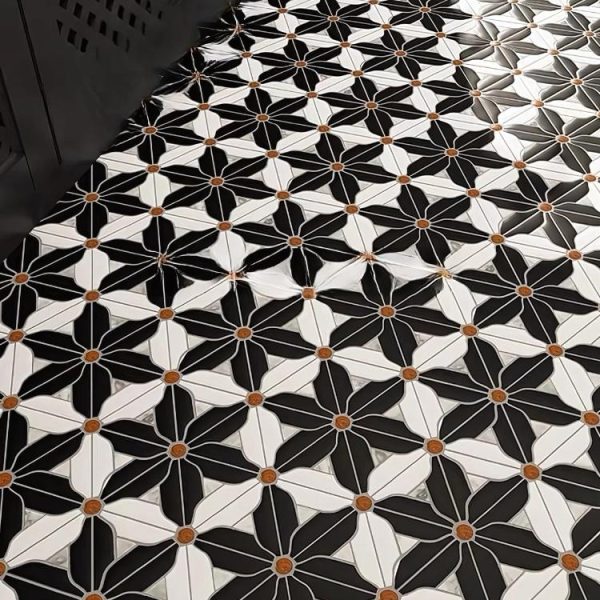 Black Hana tile featuring a striking floral pattern with white and orange accents.