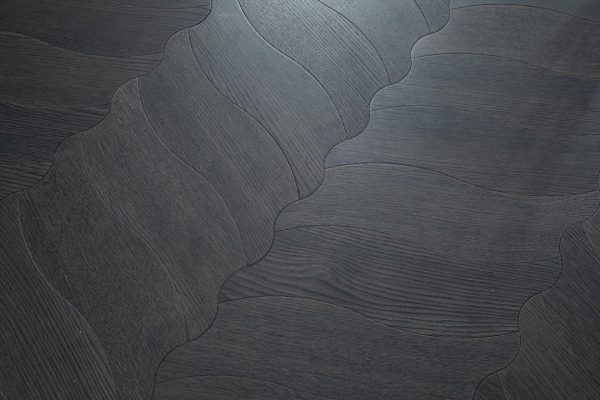 Close-up of Obsidian Flow Herringbone floorboard pattern in dark-stained oak with flowing curves