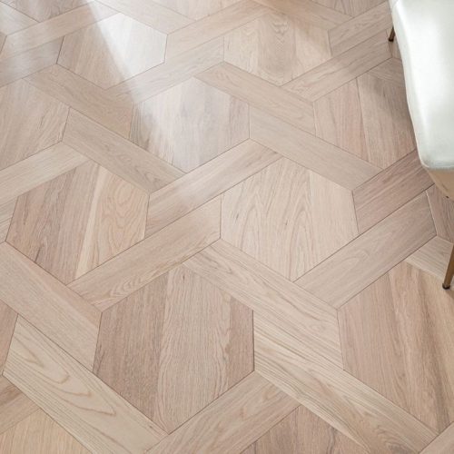 Close-up of White Oak Luxe flooring with a geometric design, highlighting the intricate pattern and natural oak texture.