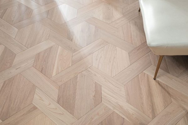 Close-up of White Oak Luxe flooring with a geometric design, highlighting the intricate pattern and natural oak texture.