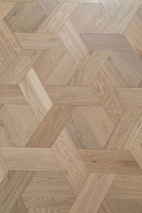 Close-up of Honeycomb Luxe oak floorboards in a geometric, interlocking pattern with a decorative vase placed on top